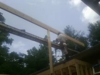 Carpenter setting a ridge beam over a new addition frame — Ice Dam Removal by Roofing Brothers in Scottsburg