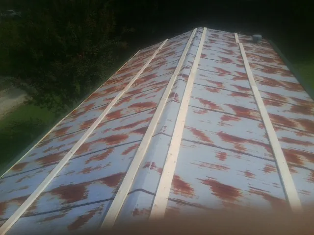 Rusted metal roof panels with new wood purlins before replacement — Storm Damage Roof Repair in Scottsburg by Roofing Brothers